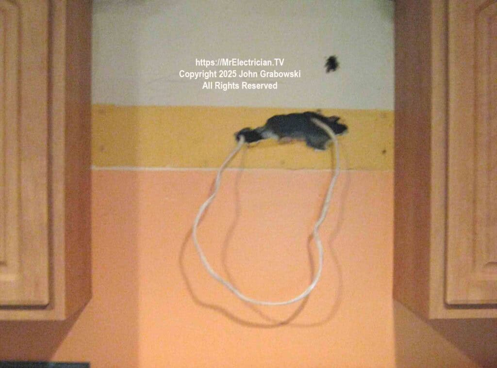 The existing electrical wiring from the old kitchen hood protruding from the wall The existing electrical wiring from the old kitchen hood protruding from the wall