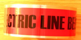 A side view of a roll of red underground electrical marking tape