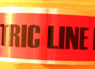 A side view of a roll of red underground electrical marking tape