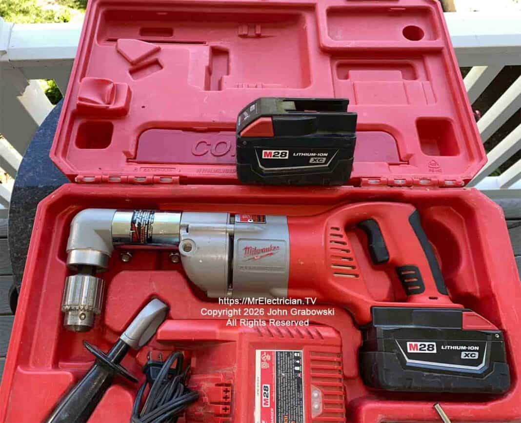 milwaukee-battery-powered-angle-drill-6099 A Milwaukee brand cordless half-inch angle drill inside of a plastic case. There's a spare battery, a battery charger, and a handle for holding the drill steady. This is not normally a DIYer tool unless some serious drilling needs to be done. Image is copyright 2026 John Grabowski, All Rights Reserved.
