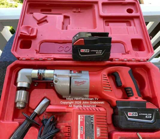 A Milwaukee brand cordless half-inch angle drill inside of a plastic case. There's a spare battery, a battery charger, and a handle for holding the drill steady. This is not normally a DIYer tool unless some serious drilling needs to be done. Image is copyright 2026 John Grabowski, All Rights Reserved.